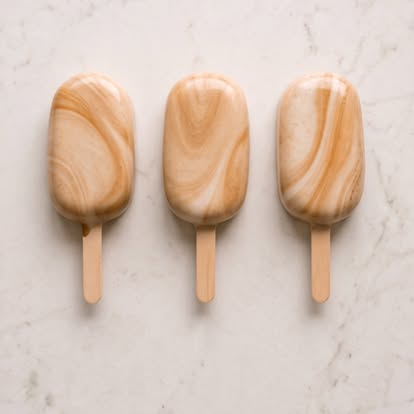 Three marbled caramel-colored cakesicles